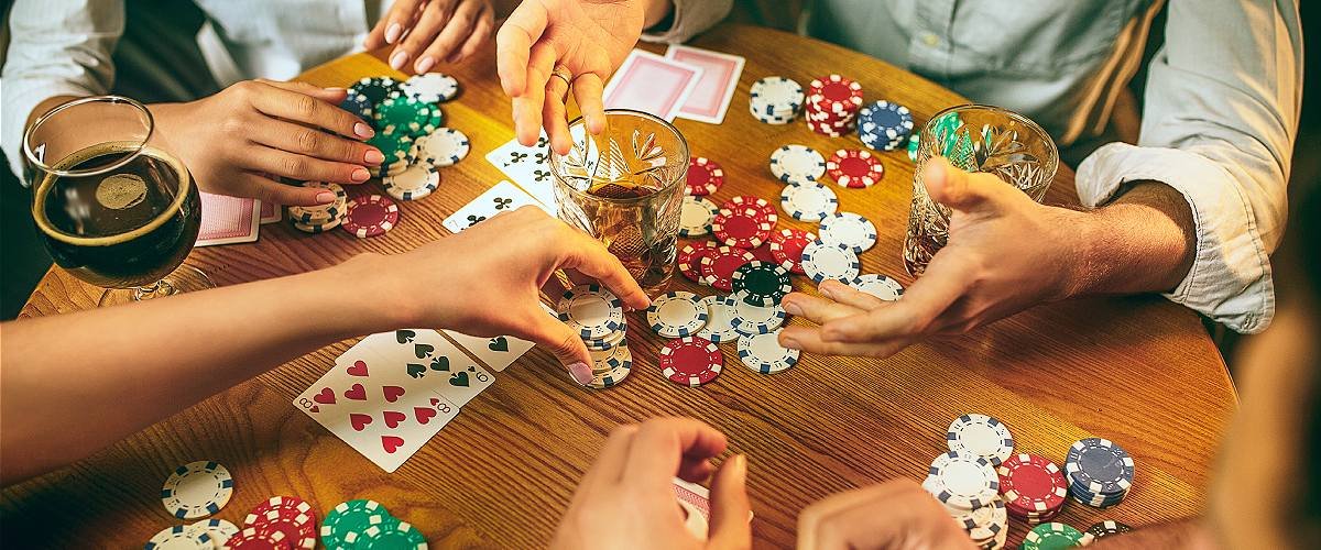 Wie man beim Poker gewinnt: Freunde am Tisch beim Pokerspielen Pokerchips und Karten liegen auf dem Tisch.